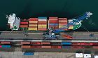 Symbolbild Lieferkettensorgfaltspflichtengesetz (LkSG): Container werden von einem Schiff auf Güterwagen geladen.